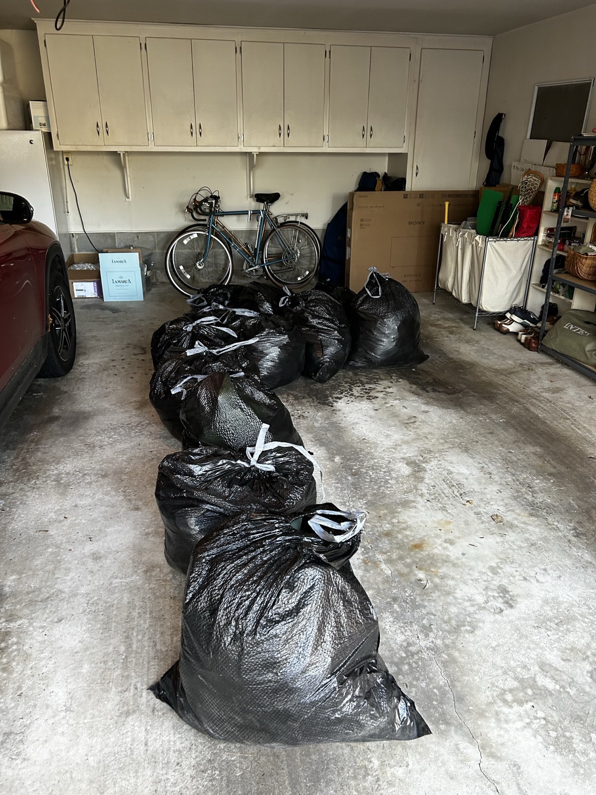 Bags of donated clothing staged in a garage for delivery to West Chester nonprofit partners